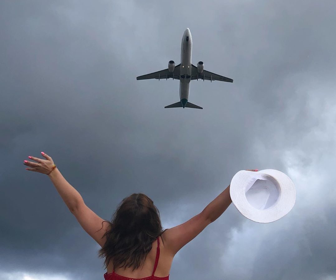 Девушка смотрит на пролетающий самолет